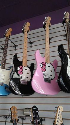 guitars with hello kitty on them are lined up against the wall in a music store