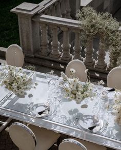 the table is set with white flowers and silverware for an elegant dinner party or special event