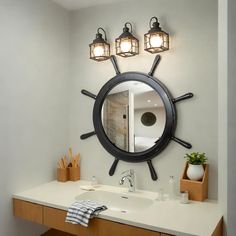 a bathroom with a sink, mirror and lights on the wall in front of it