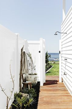 an outdoor area with wooden floors and white walls