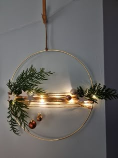 a circular mirror hanging on the wall with lights and greenery in front of it