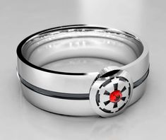 a star wars inspired ring with a red stone in the center and black stripes around it