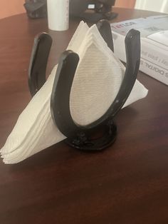 a pair of black and white napkins sitting on top of a wooden table next to a stack of books