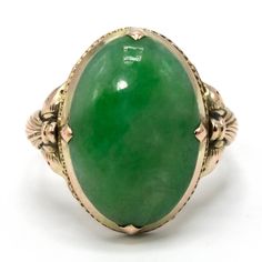 This lovely ring--probably made in the 1920s--is made of gold fill and is replete with elegantly simple Arts & Crafts design elements. The central stone is an oval piece of beautifully verdant nephrite jade. Metal: Gold Fill Main Stone: 1 Oval Cut Cabochon Jade (16.11 x 11.36 mm) Ring Size: 6.0 (can be sized) Victorian Oval Yellow Gold Emerald Ring, Victorian Oval Emerald Ring In Yellow Gold, Antique Oval Opal Gemstone Ring, Vintage Oval Jade Rings, Antique Emerald Ring Oval Cabochon, Antique Emerald Ring With Oval Cabochon, Green Oval Heirloom Jewelry, Heirloom Oval Green Jewelry, Heirloom Green Oval Jewelry