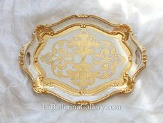 an ornate gold and white serving tray on a white cloth with the words la ballerinana gallery com