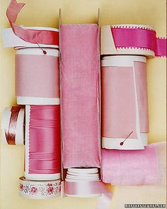 several rolls of pink ribbon are stacked on top of each other with ribbons attached to them