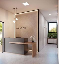 an office lobby with a reception desk and planter on the wall next to it