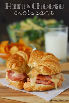 a sandwich cut in half sitting on top of a white plate next to some chips