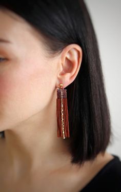 Elevate your look with these boho chic gold stud earrings featuring a stunning beaded tassel design in dark topaz. These statement long earrings in brown and gold exude an elegant charm that will surely turn heads. The glamorous dark topaz beaded tassel earrings are accentuated by trendy gold studs, making them a must-have statement jewelry piece for any occasion. Add a touch of sophistication and style to your outfit with these exquisite earrings! These earrings are very lightweight and extreme Handmade Brown Tassel Earrings, Elegant Brown Dangle Tassel Earrings, Bohemian Brown Fringe Earrings, Brown Dangling Beads Jewelry For Party, Elegant Brown Chandelier Earrings, Brown Dangle Earrings With Tassels, Brown Fringe Dangle Jewelry, Brown Fringe Tassel Earrings For Gift, Brown Fringe Tassel Earrings As Gift