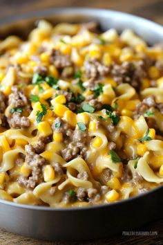 a pan filled with macaroni and cheese on top of a wooden table