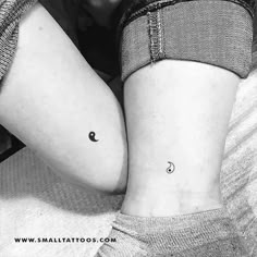 two small tattoos on the thighs, one with a crescent and another with a star