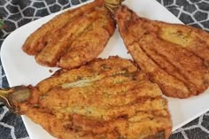 three pieces of fried food on a white plate