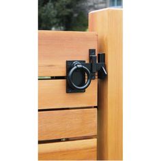 a close up of a door handle on a wooden cabinet