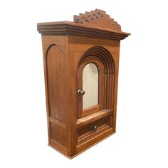 an old fashioned wooden cabinet with mirror on the front and door open to reveal it's interior