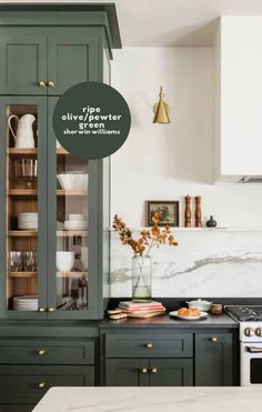 a kitchen with green cabinets and marble counter tops