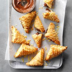 some pastries are sitting on a napkin with dipping sauce