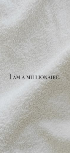 the words i am a millionaire are written in black on a white blanket