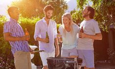 three men and a woman are having a good time at the bbq with beer