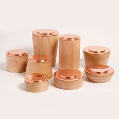 a set of wooden containers with copper lids and lids on the top, all in different shapes and sizes