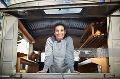 a woman standing in the back of a van