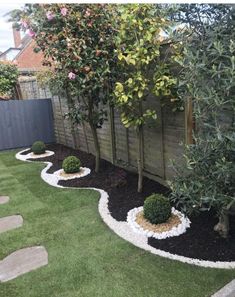 a small garden area with grass, rocks and trees in the middle is shown here