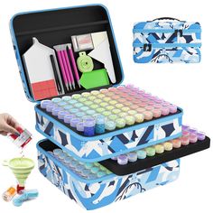 two suitcases filled with different colored paint and supplies next to each other on a white background