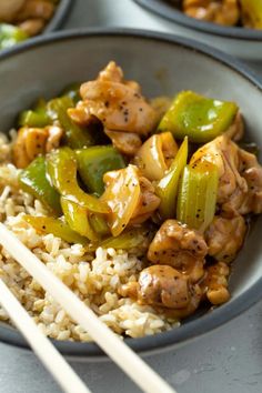 chicken, peppers and rice in a bowl with chopsticks