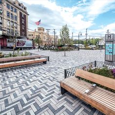 an empty city square with benches and plants