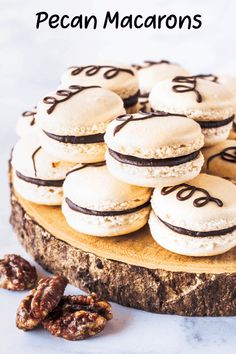 there are many macaroons that are on the wooden platter with pecans