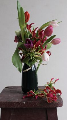 a vase filled with flowers sitting on top of a wooden table