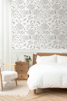 a bedroom with a bed, chair and wall paper