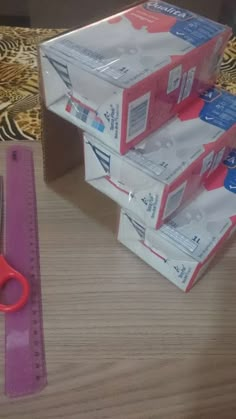 scissors and tape are sitting on the table next to some boxes that have been wrapped in plastic