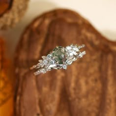 a diamond ring sitting on top of a piece of wood next to a wooden wall