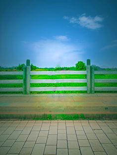 a white and green fence sitting on the side of a road