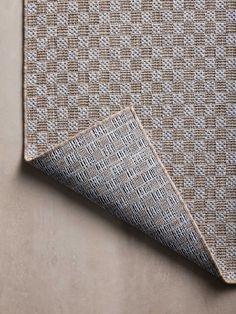 a close up view of the fabric on a wall with a tan and white checkerboard pattern