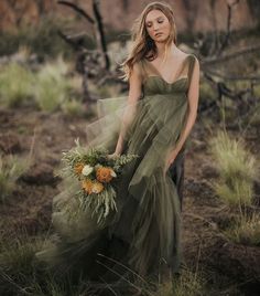 a woman in a green dress holding a bouquet