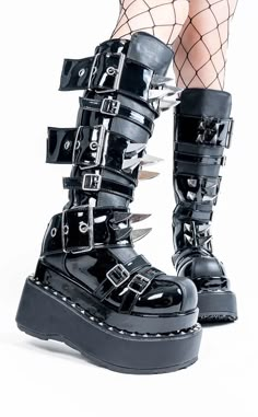 The BEAR-215s are the ideal boots for any buckles-and-claws fan - and really, who doesn't want 'em? 4 1/2 inch (114mm) platform. Vegan black leather and black patent. Tiered pyramid stud trimmed platforms. Metal claw spikes Multi size buckle strap closure. Inside metal zip closure. U.S. women's sizing-please refer to the size chart for more info. Black Grunge Platform Boots With Spikes, High-top Platform Emo Boots, Gothic Black Spiked Platform Boots, Black High-top Spiked Platform Boots, Grunge High-top Platform Boots With Spikes, Goth Roller Skates, Boots Ideas, Demonia Boots, Goth Boots