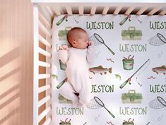 a baby is sleeping in a crib with fishing related wallpaper