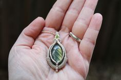 This stunning wire wrap pendant was hand-crafted using a green labradorite cabochon with a shimmering green peridot facet. These have been whimsically wrapped up in .925 sterling silver wire using intricate patterns and details.  Dimensions:   L* ~1.80 inches  W* ~1.0 inches *Silver chain sold separately* "Mindful Meandering Creations is my way of expressing creativity and sharing the love and power that working with crystals brings. I hope that through mindful practices we all as humans can come together to continue to make the world a beautiful place to call home." Kory D. Delannoy Hand Wrapped Green Sterling Silver Jewelry, Wire Wrapped Green Sterling Silver Jewelry, Green Wire Wrapped Sterling Silver Jewelry, Green Sterling Silver Wire Wrapped Jewelry, Handmade Green Labradorite Jewelry, Green Peridot Wire Wrapped Jewelry, Green Labradorite Wire Wrapped Jewelry, Handmade Peridot Pendant Jewelry, Mindful Practices