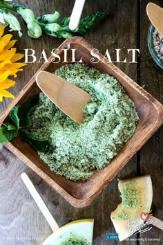 basil salt in a wooden bowl on a table next to cheese and sunflowers