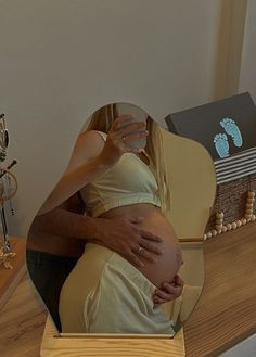 a pregnant woman is reflected in a mirror