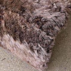 a close up view of the fur on top of a couch cushion that is made out of sheepskin