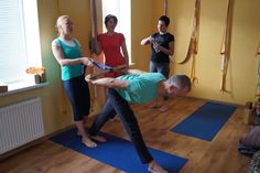 a group of people doing yoga in a room