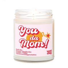 a candle with the words you da mom written in red and yellow lettering on it