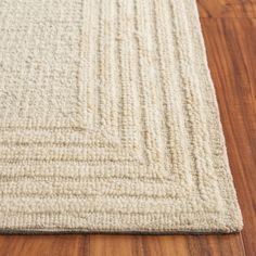 a white rug on top of a wooden floor