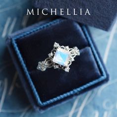 "Our current turnaround time for regular orders is 6-8 weeks. For urgent orders, please shop our Ready-to-Ship collection below (7-10 business days): https://michellia.com/collections/ready-to-ship (please copy and paste into browser) -------- 「Elsa」- Vintage Princess Square Ring, in Rainbow Moonstone | R1005 Inspired by the legendary Queen of Arendelle, this regally luxurious design features an ice-like center stone marked by its unmistakable brilliance. The vintage-inspired filigree details su White Princess Cut Jewelry With Rose Cut Diamonds, White Celestial Moonstone Ring In 14k Gold, White 14k Gold Moonstone Promise Ring, White Moonstone Promise Ring In 14k Gold, White Moonstone Celestial Ring In 14k Gold, White Moonstone Ring In 14k Gold For Promise, Heirloom White Gold Diamond Moonstone Ring, Elegant White Gold Moonstone Ring With Accent Stones, Heirloom Moonstone Ring With Rose Cut Diamonds For Wedding