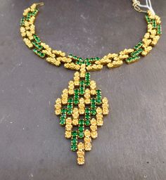 Item oxfj8 Price £125 Circa 1960 Wow this is an absolutely fabuuuuuulous necklace. This piece has a bold profile with vibrant emerald green stones and gold tone flowers, in a link design that moves and adjusts to your neckline when worn. The necklace has a substantial weight and feel and lies flush along your neckline when worn. Overall this is a well made and uniquely designed necklace. The diamond pendant measures approx. 8.5x4.5cm, the necklace measures 31cm extending to 35cm, 1.5cm wide. Green Jeweled Necklaces For Anniversary, Green Jeweled Necklace For Anniversary, Green Hallmarked Emerald Necklace For Wedding, Formal Green Emerald Necklace With Jewels, Vintage Gold Emerald Necklace For Formal Occasions, Vintage Green Emerald Necklace For Formal Occasions, Green Emerald Pendant Necklace For Formal Occasions, Formal Green Emerald Pendant Necklace, Green Necklace For May Birthstone