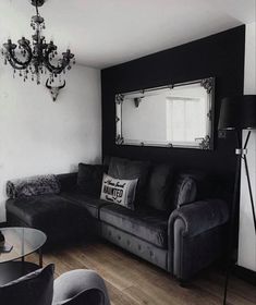 a black and white living room with couches, chairs and a chandelier