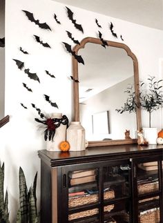 a mirror sitting on top of a wooden cabinet next to a wall filled with bats