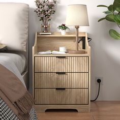 a bedroom with a bed, nightstand and plant on the side table next to it